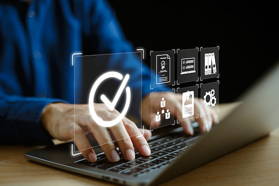 Person providing quality assurance with icons coming off laptop