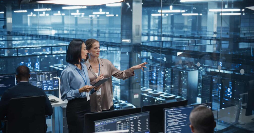 Two female engineers in data centre explaining what is network management